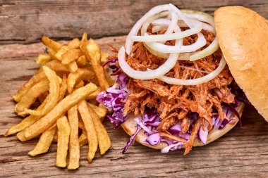 Barbekü çekti domuz sandviç ile barbekü sosu, kırmızı cabbageonion, sos ve patates salatası ahşap arka plan, Fast food