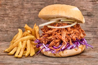 Barbekü çekti domuz sandviç ile barbekü sosu, kırmızı cabbageonion, sos ve patates salatası ahşap arka plan, Fast food