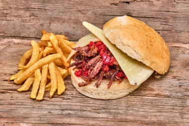 Barbekü çekti kuzu sandviç ile peynir, reçel sıcak biber, sos ve kişiler üzerine ahşap arka plan, Fast food