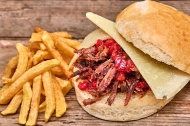 Barbekü çekti kuzu sandviç ile peynir, reçel sıcak biber, sos ve kişiler üzerine ahşap arka plan, Fast food