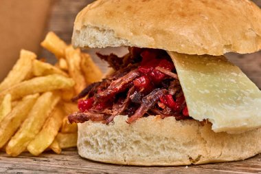 Barbekü çekti kuzu sandviç ile peynir, reçel sıcak biber, sos ve kişiler üzerine ahşap arka plan, Fast food