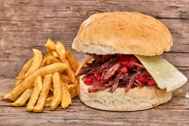 Barbekü çekti kuzu sandviç ile peynir, reçel sıcak biber, sos ve kişiler üzerine ahşap arka plan, Fast food