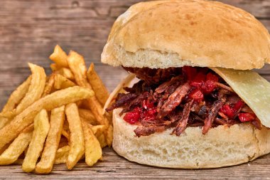 Barbekü çekti kuzu sandviç ile peynir, reçel sıcak biber, sos ve kişiler üzerine ahşap arka plan, Fast food