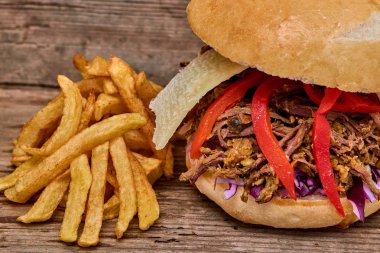 Fast food, Barbekü çekti beff sandviç peynir, biber, köri mercimek ve kırmızı lahana salatası sosu ve kişiler ahşap arka plan üzerine pişmiş