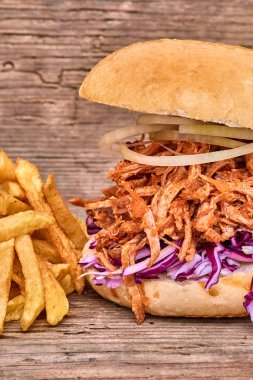 Barbekü çekti domuz sandviç ile barbekü sosu, kırmızı cabbageonion, sos ve patates salatası ahşap arka plan, Fast food