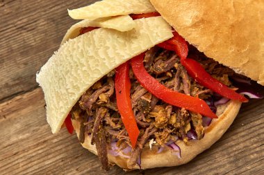 Fast food, Barbekü çekti beff sandviç peynir, biber, köri mercimek ve kırmızı lahana salatası sosu ve kişiler ahşap arka plan üzerine pişmiş