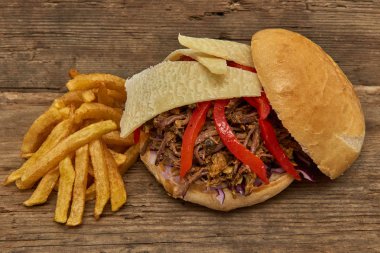 Fast food, Barbekü çekti beff sandviç peynir, biber, köri mercimek ve kırmızı lahana salatası sosu ve kişiler ahşap arka plan üzerine pişmiş