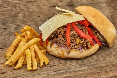 Fast food, Barbekü çekti beff sandviç peynir, biber, köri mercimek ve kırmızı lahana salatası sosu ve kişiler ahşap arka plan üzerine pişmiş