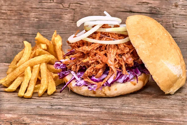 Barbekü çekti domuz sandviç ile barbekü sosu, kırmızı cabbageonion, sos ve patates salatası ahşap arka plan, Fast food