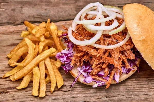 Barbekü çekti domuz sandviç ile barbekü sosu, kırmızı cabbageonion, sos ve patates salatası ahşap arka plan, Fast food