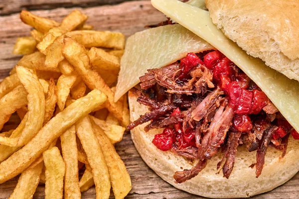 Barbekü çekti kuzu sandviç ile peynir, reçel sıcak biber, sos ve kişiler üzerine ahşap arka plan, Fast food