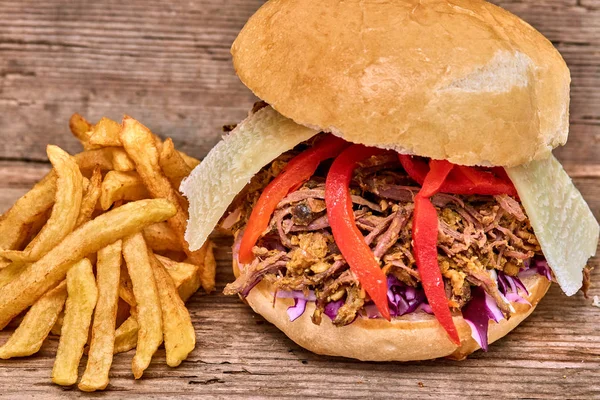 Fast food, Barbekü çekti beff sandviç peynir, biber, köri mercimek ve kırmızı lahana salatası sosu ve kişiler ahşap arka plan üzerine pişmiş