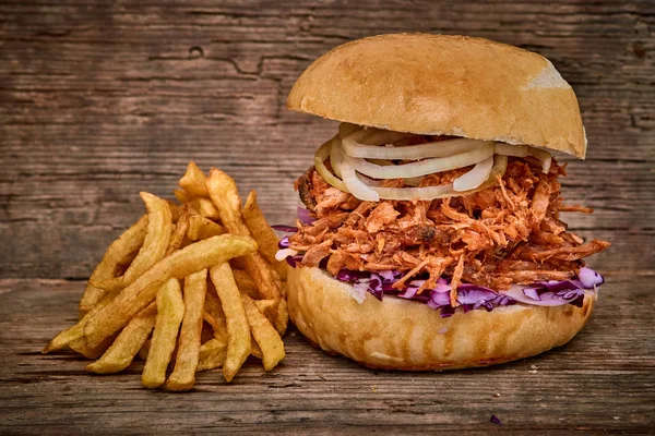 Barbeque Pulled pork Sandwich with BBQ Sauce,salad with red cabbageonion,Sauce and Fries on wooden background,Fast food