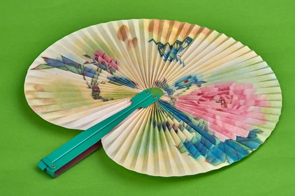 Closeup of Traditional Chinese paper fan on green background.Hand paper fan