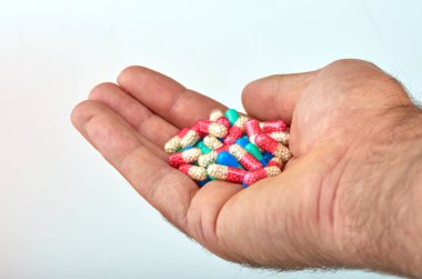 El ile farklı tip-in ilaç, tıp hapları veya kapsül elinde bir adam, palmiye. Renkli hapları ve el içinde ilaç