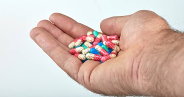 El ile farklı tip-in ilaç, tıp hapları veya kapsül elinde bir adam, palmiye. Renkli hapları ve el içinde ilaç