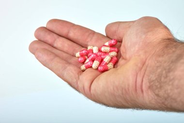 El ile farklı tip-in ilaç, tıp hapları veya kapsül elinde bir adam, palmiye. Renkli hapları ve el içinde ilaç