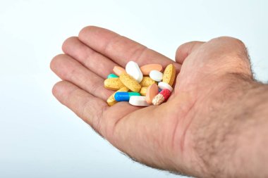 El ile farklı tip-in ilaç, tıp hapları veya kapsül elinde bir adam, palmiye. Renkli hapları ve el içinde ilaç