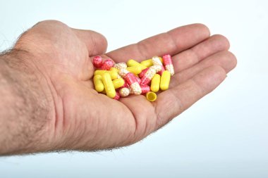 El ile farklı tip-in ilaç, tıp hapları veya kapsül elinde bir adam, palmiye. Renkli hapları ve el içinde ilaç