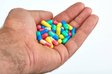 El ile farklı tip-in ilaç, tıp hapları veya kapsül elinde bir adam, palmiye. Renkli hapları ve el içinde ilaç