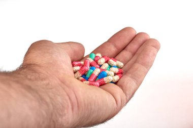 El ile farklı tip-in ilaç, tıp hapları veya kapsül elinde bir adam, palmiye. Renkli hapları ve el içinde ilaç