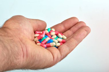 El ile farklı tip-in ilaç, tıp hapları veya kapsül elinde bir adam, palmiye. Renkli hapları ve el içinde ilaç
