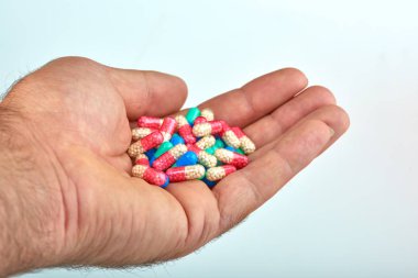 El ile farklı tip-in ilaç, tıp hapları veya kapsül elinde bir adam, palmiye. Renkli hapları ve el içinde ilaç