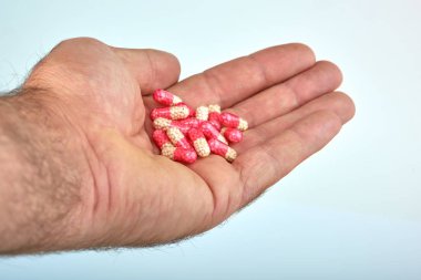 El ile farklı tip-in ilaç, tıp hapları veya kapsül elinde bir adam, palmiye. Renkli hapları ve el içinde ilaç