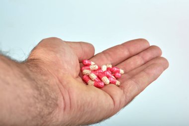 El ile farklı tip-in ilaç, tıp hapları veya kapsül elinde bir adam, palmiye. Renkli hapları ve el içinde ilaç