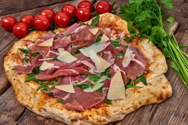 Ev yapımı taze lezzetli gurme pizza whit grana peynir, ham ham ve roket, ahşap masa, yakın seçici odak ile izole lezzetli İtalyan pizza
