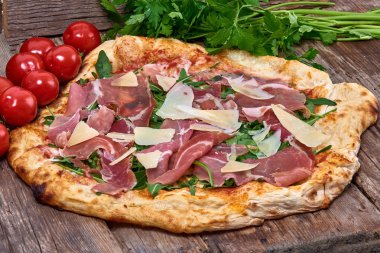 Ev yapımı taze lezzetli gurme pizza whit grana peynir, ham ham ve roket, ahşap masa, yakın seçici odak ile izole lezzetli İtalyan pizza