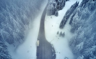 Yüksek dağ dolambaçlı yoldan hava görünümünü geçmek karla kaplı ağaçlar Transilvanya, Romanya, dron kış zamanında kavisli yol manzarası ile