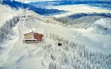 Hava üzerinde Karpatlar dağlarda muhteşem kayak pistleri, Panoramic görünümü üzerinde kayak pisti Poiana Brasov kayak merkezi Transilvanya, Romanya, Avrupa'da kış sezon karla kaplı çam ormanı