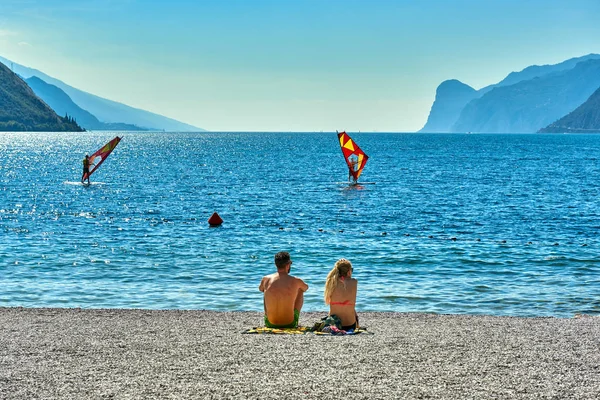 トルボレ イタリア 2018 はビーチ ラウンジの椅子の上に座って 夏の時間 山に囲まれた美しいガルダ湖のビューでガルダ湖を眺めながらの — ストック写真