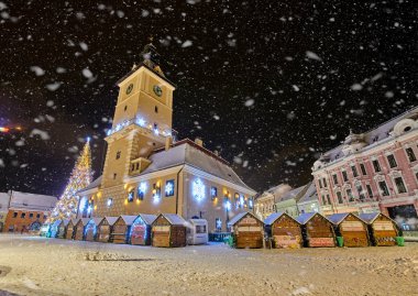 Brasov, Romania- 06 January 2019:Christmas Tree in the old city center of Brasov in a snowing night,Panoramic view of the old town and  Council Square