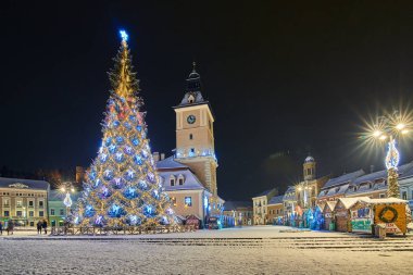 Brasov, Romania- 06 January 2019:Christmas Tree in the old city center of Brasov in a snowing night,Panoramic view of the old town and  Council Square