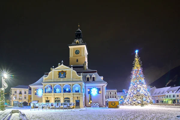 Brasov, Romania- 06 January 2019:Christmas Tree in the old city center of Brasov in a snowing night,Panoramic view of the old town and  Council Square