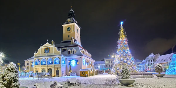 Brasov, Romania- 06 January 2019:Christmas Tree in the old city center of Brasov in a snowing night,Panoramic view of the old town and  Council Square
