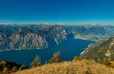 Garda Gölü üzerinden Monte Baldo, sonbaharda dağlarla çevrili muhteşem Garda Gölü Italy.Panorama görünümünü