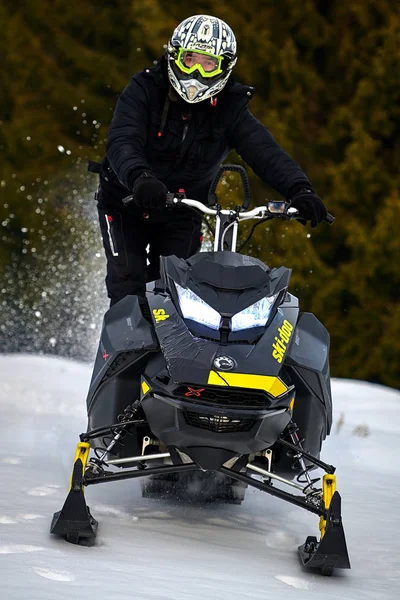 Tusnad, Romanya - 02 Şubat 2019: bir adam dağlarda, kar arabası Tusnad, Romanya'da snowmobile sürüş adam biniyor