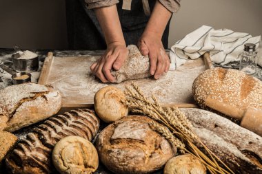 Baker'ın elleri pasta kurulu çiğ hamur yoğurma. Bütün tahıl somun ekmek - küçük fırın sahne yapma.