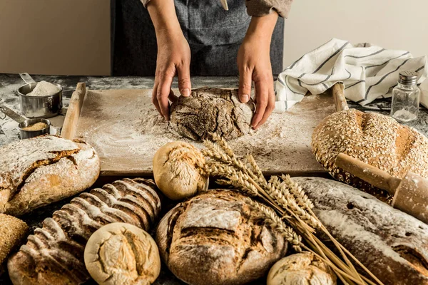 Bütün tahıl somun ekmek - küçük fırın sahne yapma. Baker'ın elinde çiğ hamur.