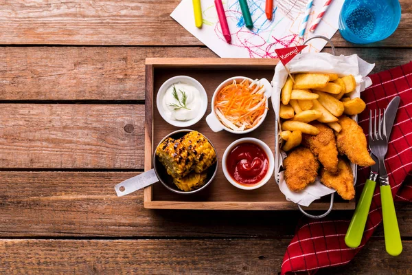 子供の食事 - チキンストリップ、フライドポテト、ローストトウモロコシとサラダ — ストック写真