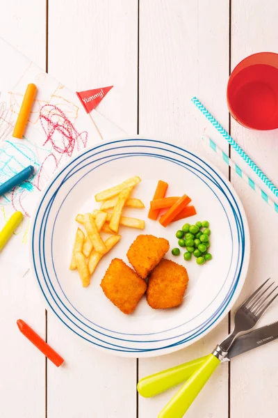 Детская еда (ужин) - куриные наггетсы, картошка фри, морковь и зеленый р — стоковое фото
