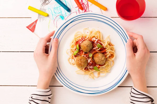 Meal (dinner) in child's hands - spaghetti and meatballs — Stock Image Meal (dinner) in child's hands - spaghetti and meatballs Royalty Free Stock Images