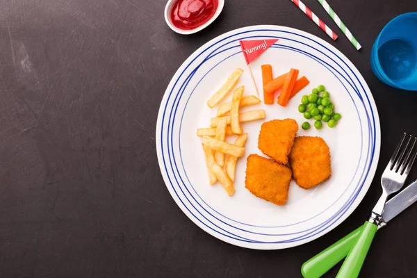 Çocuk yemeği (akşam yemeği) - tavuk nuggets, cips ve yeşil bezelye