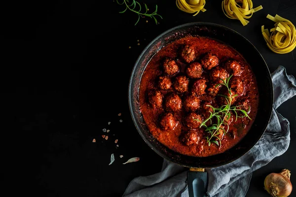 Bakso dalam saus tomat di panci latar belakang hitam — Stok Foto