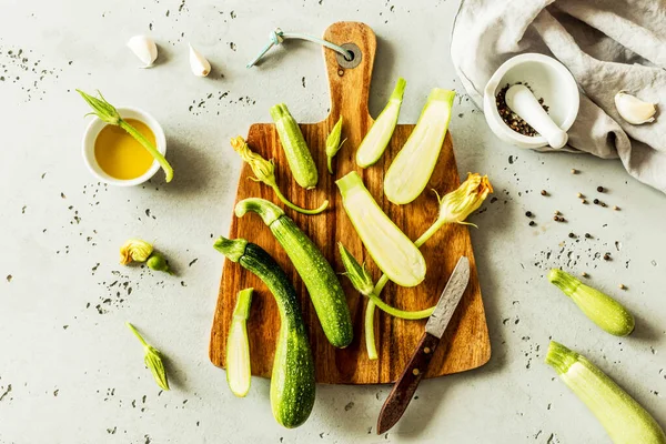 Memasak - bayi zucchini segar dengan bunga di papan kayu — Stok Foto