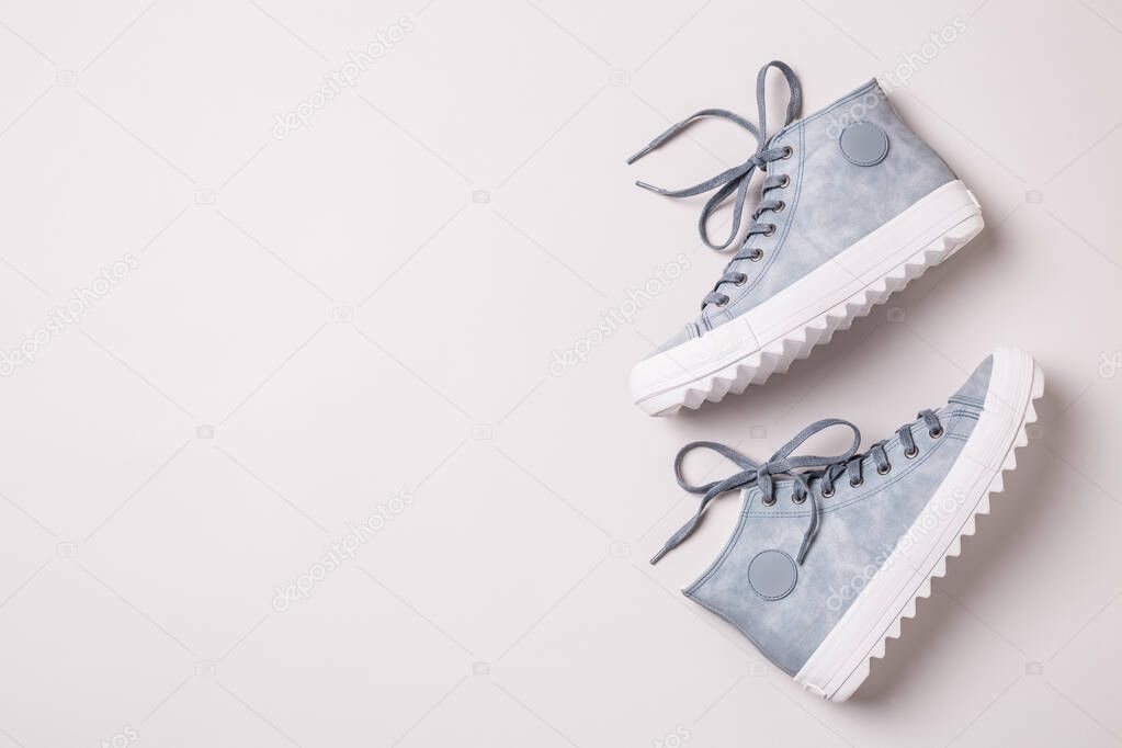 Pastel blue sneakers on grey background - footwear