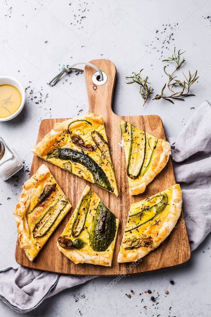 Pizza with baby zucchini on wooden board - party snack
